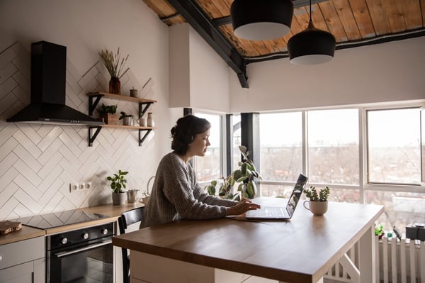 Woman Reading laptop in kitchen